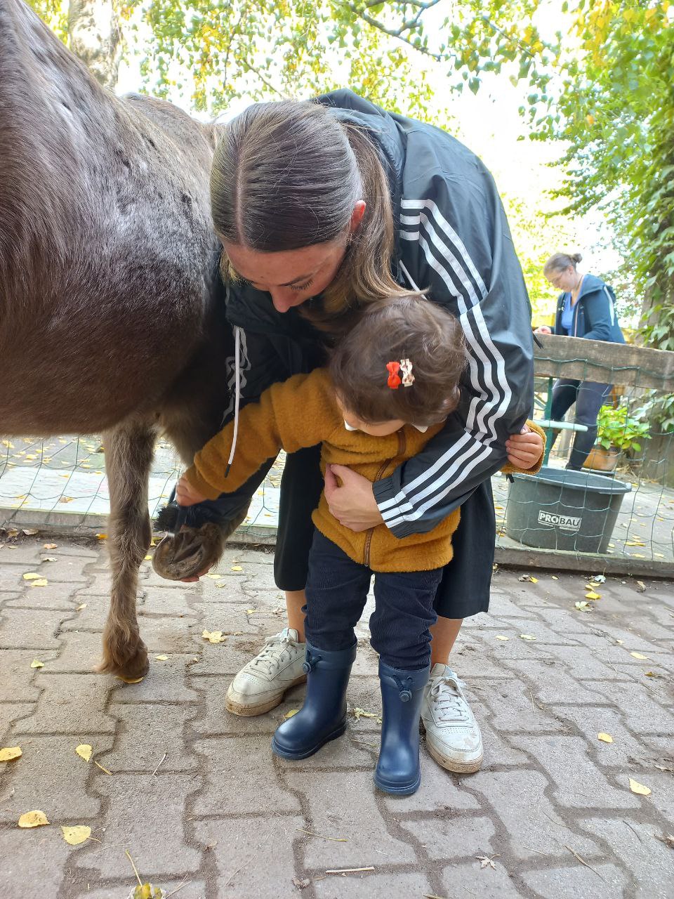 Frau und Kind streicheln Pony